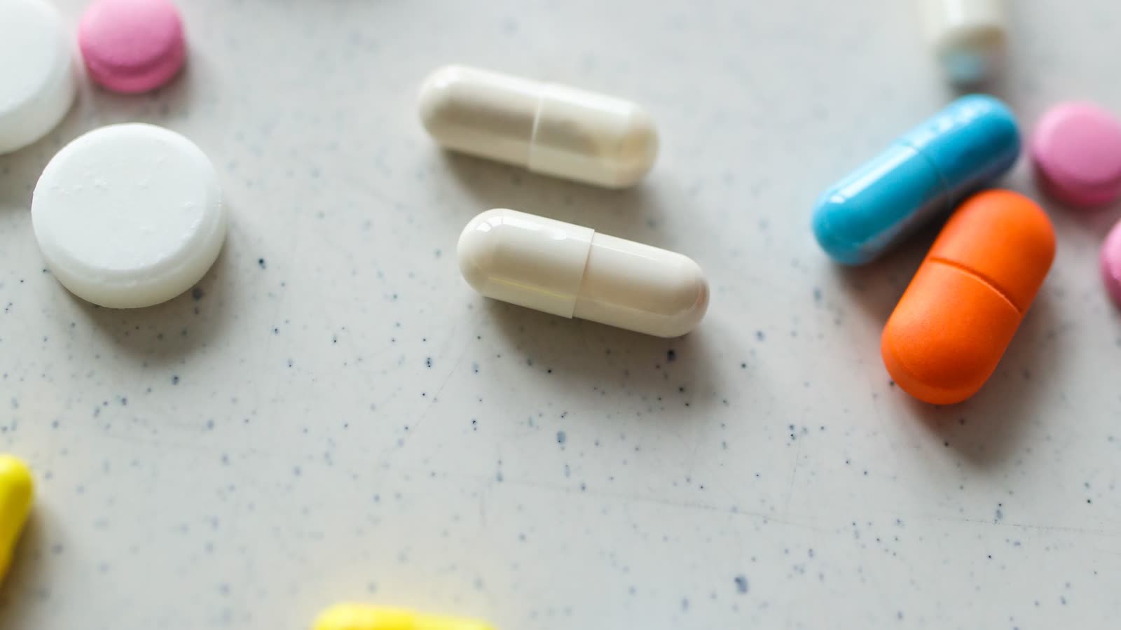 Verschillende capsules en tabletten op een lichte ondergrond